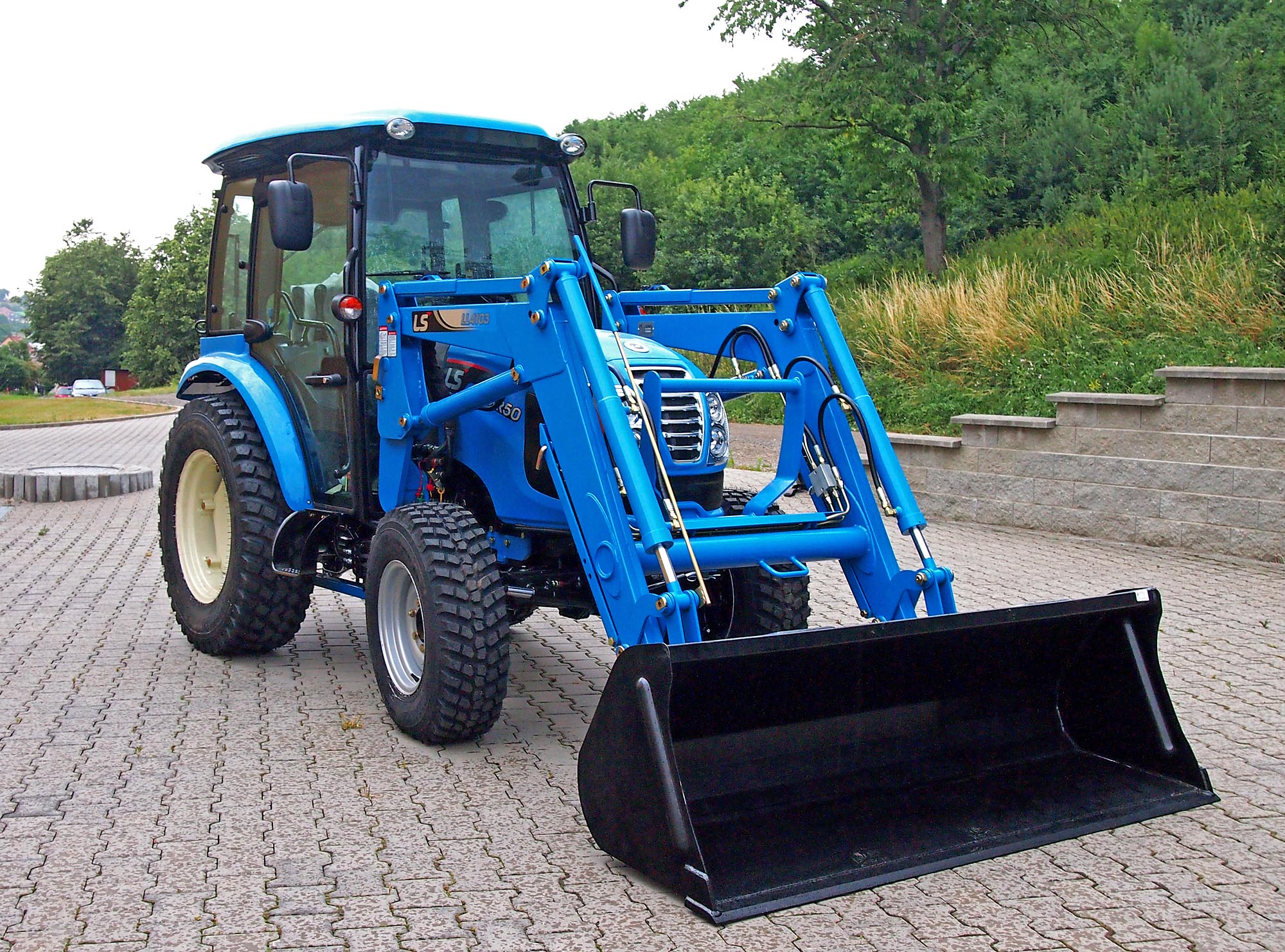 Komunální traktor LS model XR50 s čelním nakladačem.
